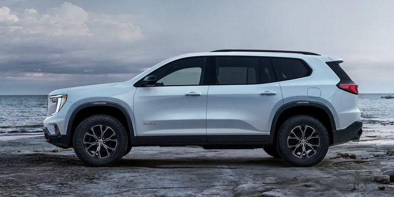 2026 GMC Acadia white vehicle parked by the waterfront